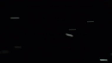 Işık örtüsü. Işın yansıması. Beyaz renk, soyut koyu arkaplanda hareket eden parlak, pırıl pırıl parlayan bir parıltı saçar..