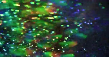 Bulanık festival ışıkları. İşaret fişeği. Yeşil mor lens, soyut parlak arkaplanda parıldayan modern sanatta titreşir..