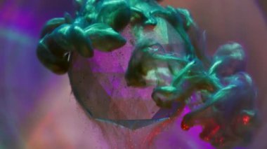Düşen boya. Sis mürekkebi. Parlak sanat dumanı cam elması kaplıyor. Polonyalı çok renkli karışım neon sıvısı çözünmüş yuvarlak mercek arka planı.