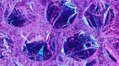 Neon damlası. Su parıltısı. Bulanık mor renkli boya pulları, kimyasal ışık soyutlamasında jel yaratıcı ıslak doku..