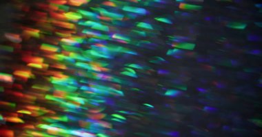 Odaklanamayan ışık patlaması. Gökkuşağı parıltısı. Soyut bokeh ışıltısı arka planında bulanık mavi turuncu çok renkli mercek.