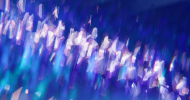 Parlayan parçacıklar dağıldı. Bulanık ışık kıvrımları. Mavi mor parlak arkaplan üzerinde bokeh etkisi ile dönen beyaz renkli lens parlaklığı.