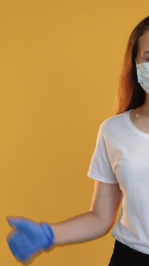 Dikey video. Onaylama işareti. Karantina sınıfı. Koronavirüs salgını. Korunaklı yüz maskesi eldivenli kendine güvenen bayan öğretmen..