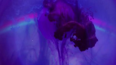 Sanat sızıntısı. Elmas değerli taş. Mor mavi menekşe sıvısı cam figürün üzerine düşer. Yuvarlak neon rengi arkaplanda boya karışımı.