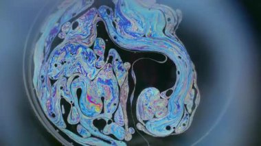 Spektrum sabunu. Yağ pigmenti. Odaklanamayan siyah arkaplanda renkli yuvarlak lens. Soyut yüzen benzin neon mürekkep harmanlanmış sıvı sürreal yüzey.