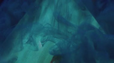 Duman dalgası. Su altyapısı. Odaklanmamış mavi bronz renk ıslak sıvı piramit boya deseni soyut koyu siyah sanat üzerine.