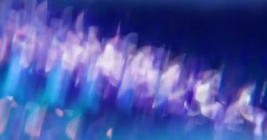 Hafif bir girdap. Parlak partiküller. Beyaz parıltılı mercek yanıp sönüyor. Mavi mor parlak, dumanlı bokeh arkaplanı açıyor..