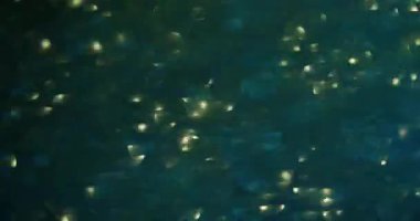 Bulanık altın kıvılcımlar. Aydınlanmış göz kamaştırıcı. Modern ışık soyut arka planında yüzen çok renkli pembe yeşil parıltılı lens..