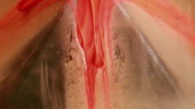 Boya damlaları. Sanat bulanıklığı. Siyah piramit yüzeyine renk jeli damlaları dökülüyor. Mistik turuncu dumanlı su emülsiyonu soyut duman arkaplanını çözdü.