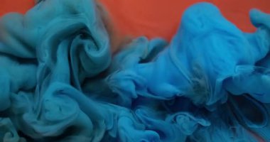 Sıçrama sanatı. Sıvı doku. Odaklanmamış mavi turuncu renkli duman parlak akrilik madde kimyasal mürekkep soyut arkaplanda yüzüyor.