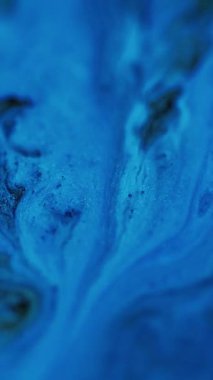 Dikey video. Islak sim dokusu. Boya arabası. Odaklanamayan mavi renkli parıldayan parçacıklar akrilik mürekkep suyu mermer karışımı dalga hareketini soyut sanat arkaplanı.