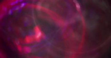 Görüntü kıvılcımlar saçar. Bokeh daireleri. Çok renkli kırmızı, mavi, mor, parlak mercek koyu soyut arkaplanı açıyor..