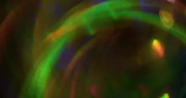 Bulanık kıvılcımlar. Bokeh ışığı. Parıldayan yeşil turuncu mavi renk desen soyut koyu siyah modern arka planda kıvrılıyor..