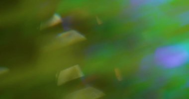 Odaklanamayan ışık girdapları. İşaret fişeği çemberi. Bulanık yeşil sanat arka planında soyut yeşil mor renkli lens yüzüyor.