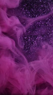 Dikey video. Islak, köpüklü bir doku. Parlak sıvı. Bulanık mor pembe sigara dumanı parıldayan kum tanecikleri su mürekkebi pigment emülsiyon akışını boyarlar.
