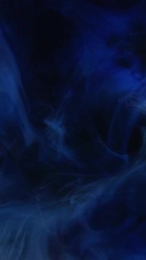 Dikey video. Sigara içilen resim. Yağ sıvısı. Su çekin. Parlak girdap. Kahin küresi. Koyu siyah sanat soyut arka planında parıldayan mavi renk, parıldayan tahıl dokusu bulutu..