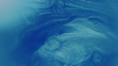 Parıldayan yağ damlaları. Bulanık boya sıvısı. Mavi beyaz çok renkli akışlar parıldayan sıvı parlayan su noktaları soyut bokeh ışık arkaplanı üzerinde hareket ediyorlar.