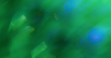 Parıltı parlıyor. Odaklanmamış parıltı dokusu. Pürüzsüz bulanık bokeh efekti üzerinde süzülen ışık parçacıkları mercek alevi yeşil mavi çok renkli arkaplan.