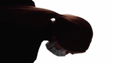 Dikey video. Hava kirliliği. Yüz silueti. Çevresel bir sorun. Beyaz boş alanda izole edilmiş koruyucu maskeli kadın başının koyu arka plan çizgisi..