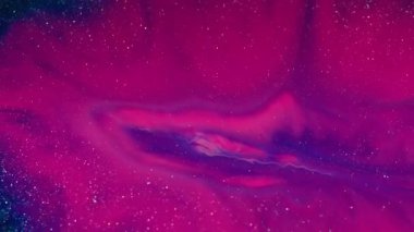 Işıldayan sıvı. Neon boya. Mor pembe leke menekşe parlak toz bulutu altında kayboluyor. Parlak pigment karışık soyut arkaplan.