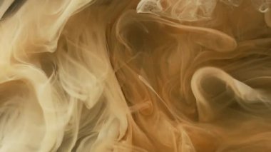 Duman karışımı. Haze boyası. Sarı kahverengi duman hipnotik kıvrım sıvıda akıyor. Odaklanmış sanatı boyamış renk suyu soyut arkaplanı çözer.