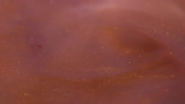 Mürekkep akışı. Köpüklü boya. Odaklanmamış sarı turuncu renkli kimyasal su parlatıcısı soyut sanat eserlerinin arka planında sıvı damlatıyor..