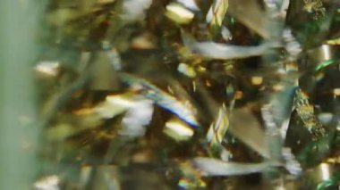 Görüntü kutlaması harika. Noel kurdeleleri. Işıldayan sarı altın rengi parlak parçacıklar soyut bokeh ışık arkaplanı üzerinde hareket ediyorlar.