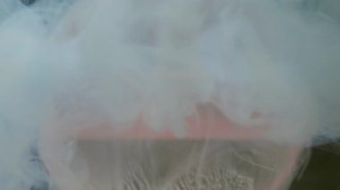 Bulut dumanı. Küre damlıyor. Odaklanmamış pembe renk su dokusu sıvı buhar dalgası soyut sanat üzerine yayılıyor koyu siyah arkaplan.