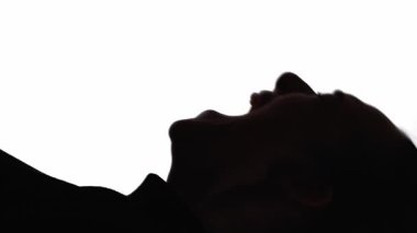 Dikey video. Çığlık atan siluet. Zihinsel bozukluk. Sinir krizi. Duygusal bir kriz. Beyazlar içinde izole bir şekilde bağıran, hayal kırıklığına uğramış bir kadının koyu renk karşıtlığı..