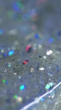 Dikey video. Parlak sıvı damlası. Parlak doku. Bulanık holografik parlak pullu parçacıklar şeffaf su jeli sıvı akışı soyut sanat arka planı ve bokeh ışıkları.