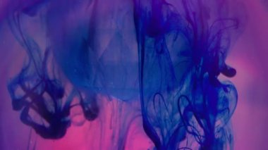 Boya çözülür. Cam kristal. Floresan mavi duman pigmenti elmastan dökülüyor. Pembe parlayan arka plan renk değiştiren su lensi.