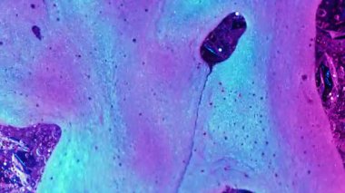 Floresan sıvısı. Boya akışı. Bulanık mor neon renkli su, kimyasal, diş minesi, akrilik kabarcıklar soyut desenli arka plana damlıyor..