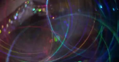 Renkli disko parıltısı. Bulanık, neşeli bir ışık. Sarı mavi turuncu daireler koyu arkaplanda soyut parlak bokeh ışığı üzerinde hareket ediyor.