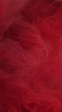 Dikey video. Çok sıcak. Buz ateşi alevi. Odaklanmamış kırmızı boya, parlayan ışık, yüzen bulut dokusu sıçratıyor. Soyut arkaplanda renk dumanı.