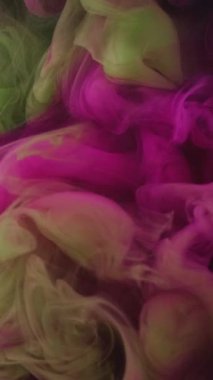 Dikey video. Sıvı boya. Artistik fırça. Güzel tasarım. Pigment su altında yavaş karışım hareketi. Modern sanatın soyut arka planında pembe yeşil renk karışımı.