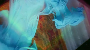 Boya damlası. Akrilik akım. Piramit oniks taşı şekli mavi pigment kaydırak siyah arkaplan su altında soyut sanat gökkuşağı ışık huzmesi bulanıklığı.