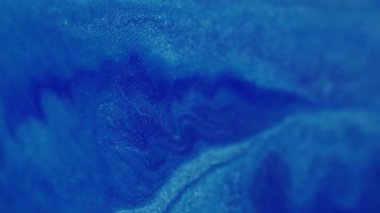 Bulanık parıltı sıvısı. Su parıldıyor. Işıl ışıl beyaz, yanıp sönen sıvı boya mürekkebi parlak toz, soyut bokeh ışık arka planında hareket ediyor..