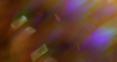 Odaklanamayan ışık. Renkli bir parıltı. Parlak parçacıklar, mor turuncu gölgeler, bulanık bokeh arka planda parlayan mercekler..