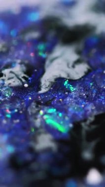 Dikey video. Köpüklü sıvı. Mürekkep sıçraması. Bulanık mor renkli parlak pullu simli parçacıklar boya sıvı dökülme hareketli soyut sanat arka planı Bokeh ışıkları.