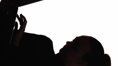 Dikey video. Dijital siluet. İnternet işi. Modern teknoloji. Dizüstü bilgisayarla çalışan, beyaz boş arkaplanda izole edilmiş, bağımsız çalışan bir kadının koyu çizgisi..