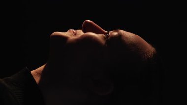 Dikey video. Mutlu siluetler. Barış uyumu. Yüzü koyu renk, neşeli, gülümseyen bir kadın. Siyahların üzerinde yalnızlığın tadını çıkarıyor..