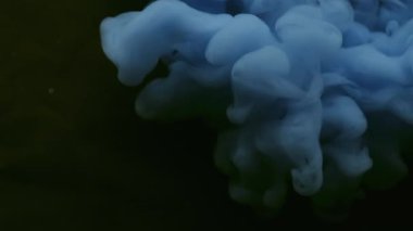 Haze mürekkebi. Mistik duman. Siyah yüzeye mavi bulut spreyi döküldü. Suyun soyut arka planında renk üfürüğü bulanık pigment patlaması.
