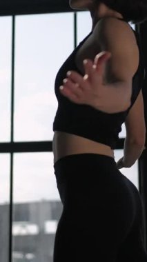 Dikey video. Vücut gerilmesi. Fitness eğitimi. Spor kadın yoga eğitmeni aktivite kıyafetleri fiziksel antrenman. Spor paspasının ısınma seansı. Spor salonu içinde..