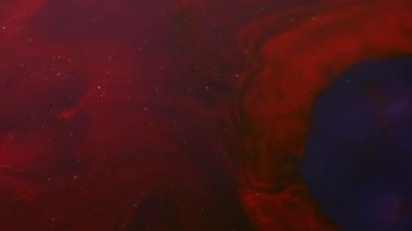 Karışık su sıçratma. Sıvı dökülmesi. Soyut koyu siyah arkaplan üzerine dökülen suda çözünmüş kırmızı renkli kimyasal mermer emülsiyonu.