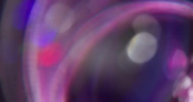 Odaklanmamış disko rengi. Parıltı parlıyor. Neon ışıklı mercek ışıltısı, bokeh arkaplanlı bulanık bir şekilde dönen optik daireler..