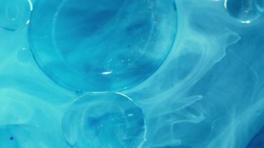 Parıldayan parçacıklar. Sıvı jel. Odaklanmamış mavi renk moleküler boya lekeli asit su akışı soyut sanat akrilik arka planda yayılıyor.