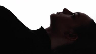 Dikey video. Kadın silueti. Yüz hatları. Beyaz boş arkaplanda izole edilmiş koyu siyah kontrast kadın portresinin ana hatları.