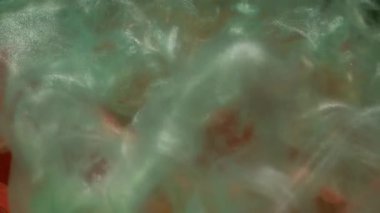 Köpüklü sıvı. Akış dumanı. Odaklanmamış kırmızı turuncu renk çiçek yaprakları parlak ıslak boya doğası soyut koyu siyah sanat arka planına sıçramış..