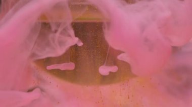 Duman damlası. Mürekkep sıçraması. Odaklanmamış pembe altın rengi toz boyası kimyasal su damlası soyut sanatının koyu siyah arka planına yayılıyor..