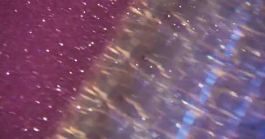 Parıltı parıltısı. Odaklanamayan soyutlama. Bokeh açık pembe mor parlak arkaplan üzerinde bulanık renkli parlak beyaz parçacıklar.